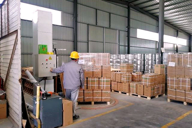 The packing area at the Chengdu warehouse, cartons staged on pallets beside the shelving.
